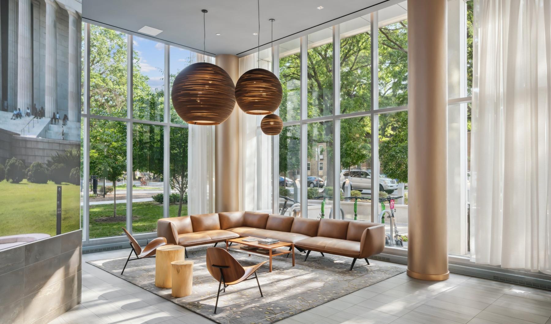 a room with a couch and chairs and large windows